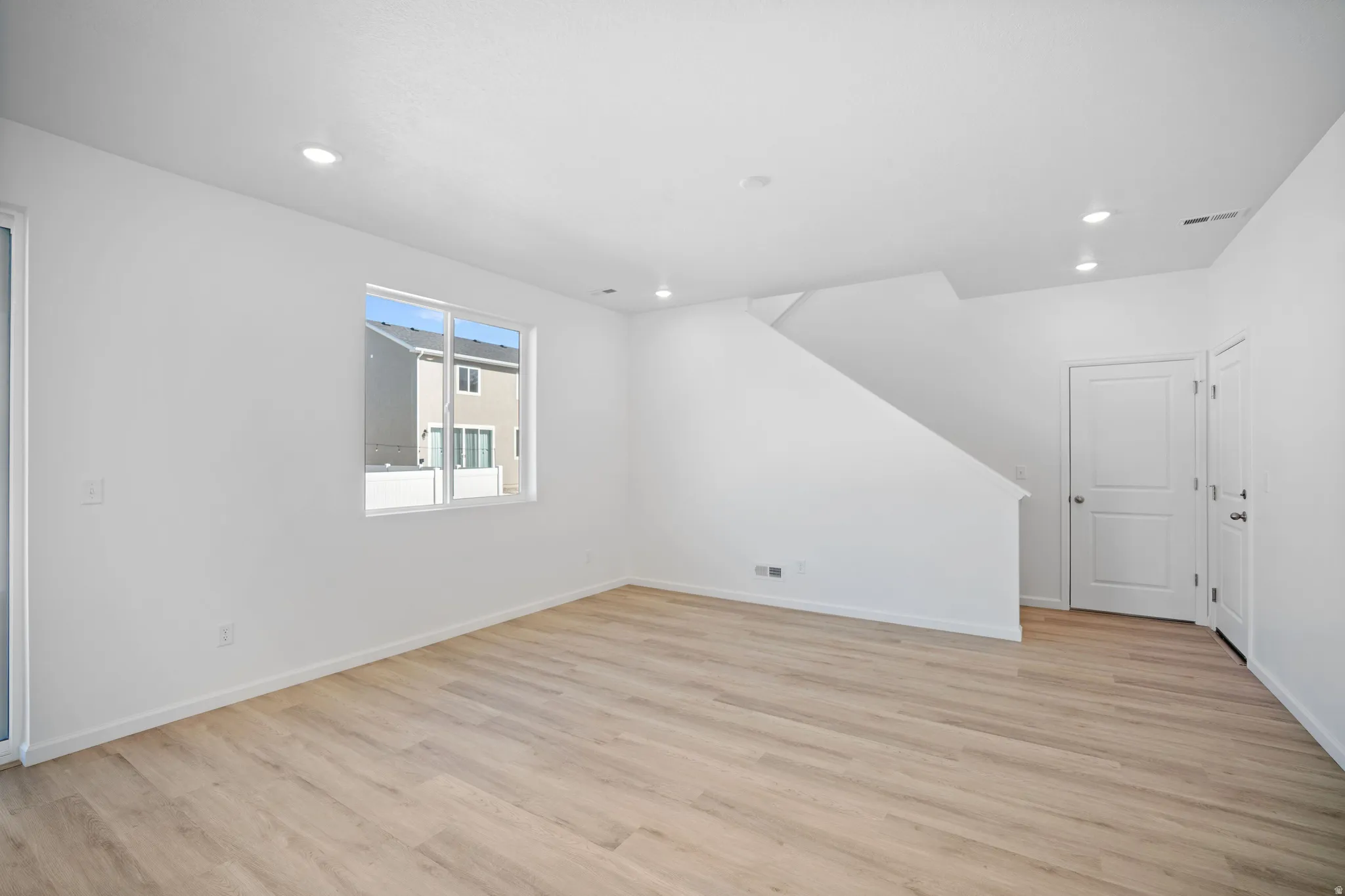 Bonus room with light wood-style flooring and recessed lighting