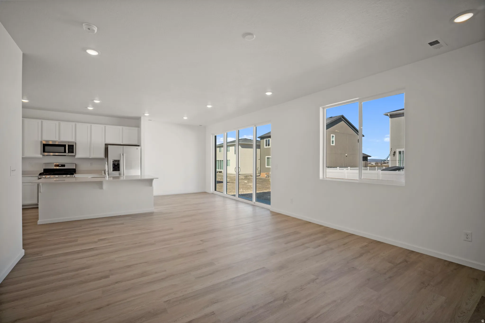 Unfurnished living room with recessed lighting and light wood-type flooring