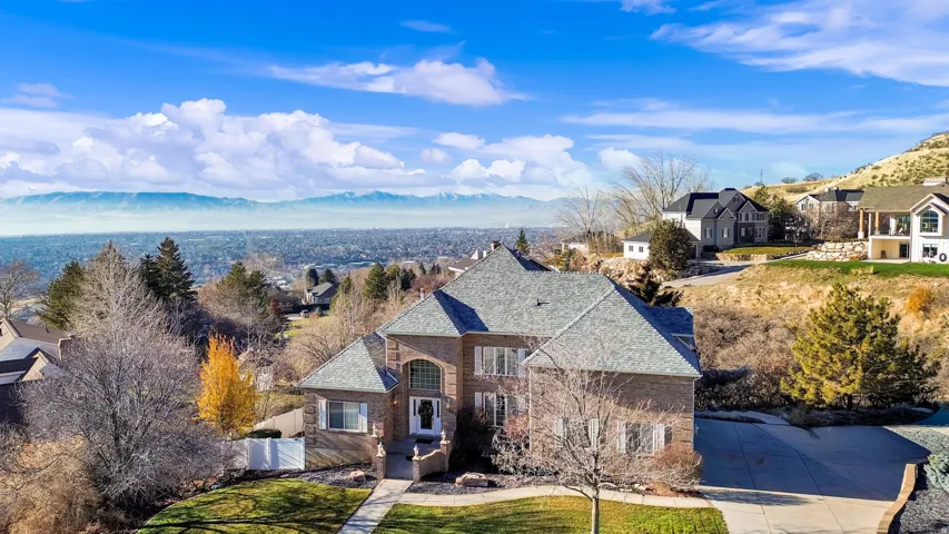 French provincial home featuring a mountain view, brick siding, a residential view, and a front lawn