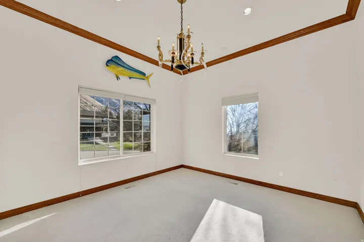 Unfurnished room with ornamental molding, a chandelier, carpet, plenty of natural light, and recessed lighting