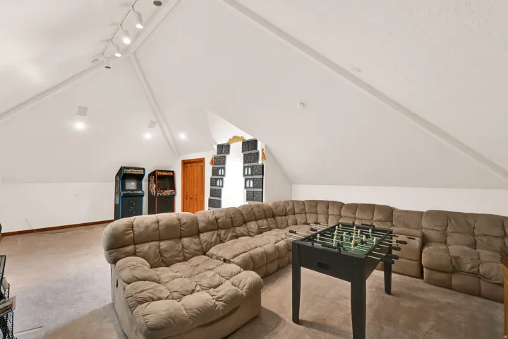 Carpeted living area featuring vaulted ceiling