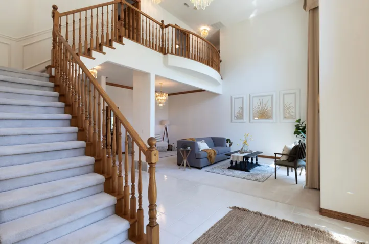 Stairs with a chandelier, a towering ceiling, and tile patterned floors