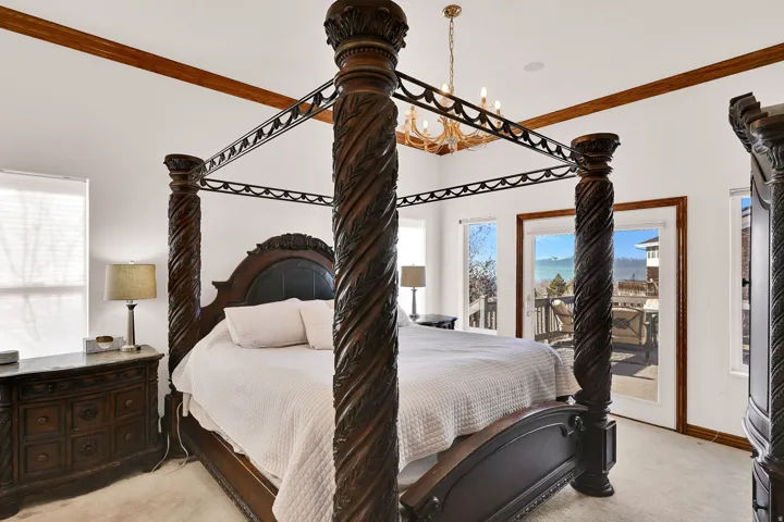 Bedroom with light carpet, access to outside, and crown molding