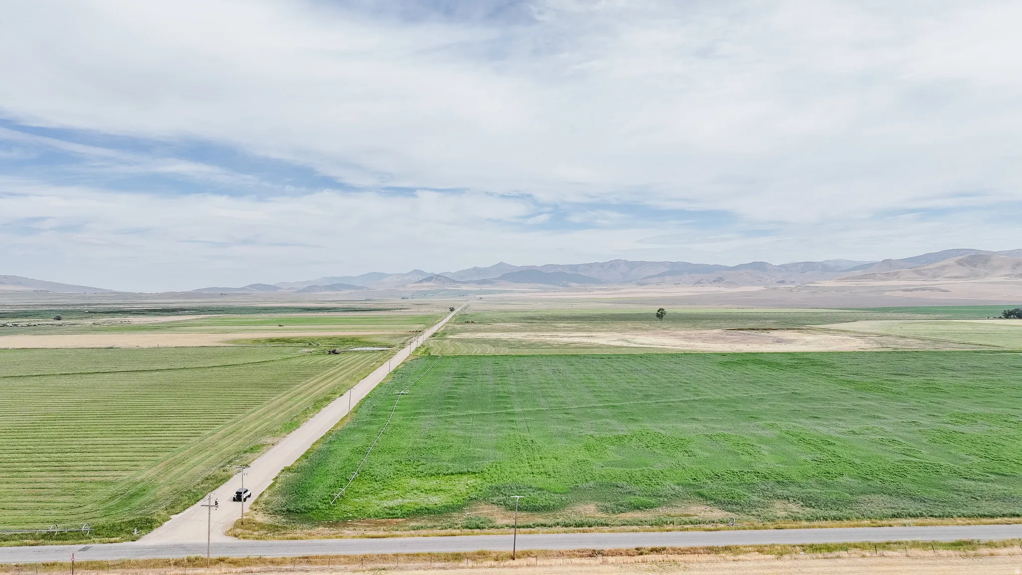 View of grassy yard featuring a view of countryside, agricultural area, and a mountain view