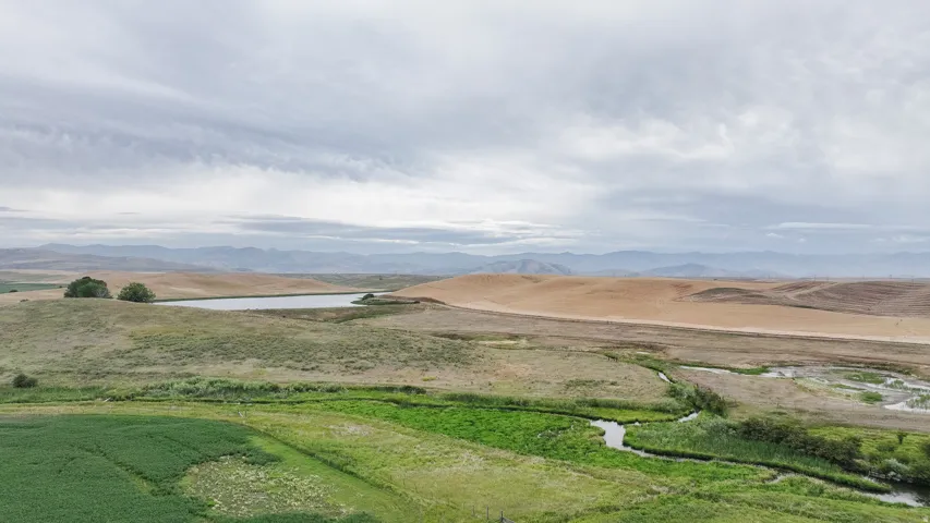 View of mountain background with rural landscape and a large body of water