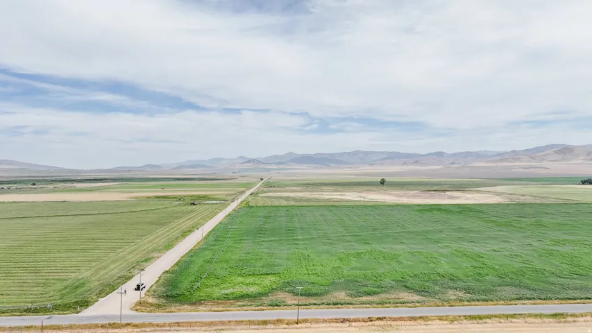 View of grassy yard featuring a view of countryside, agricultural area, and a mountain view