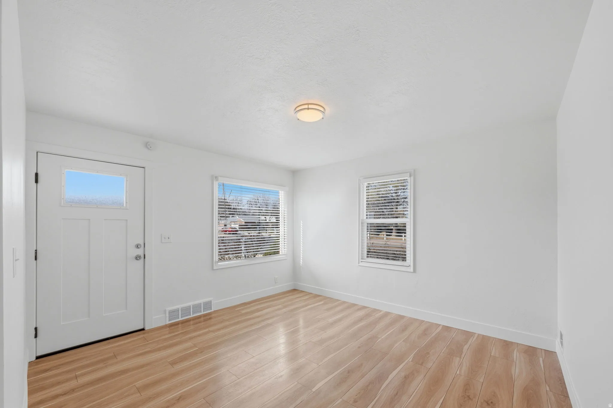 Foyer entrance featuring light wood-type flooring and baseboards