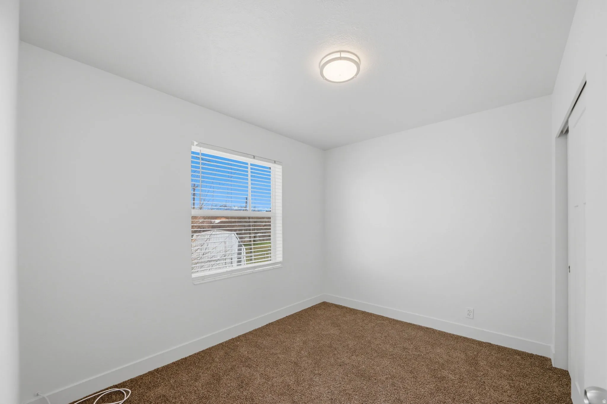Spare room with baseboards and dark colored carpet