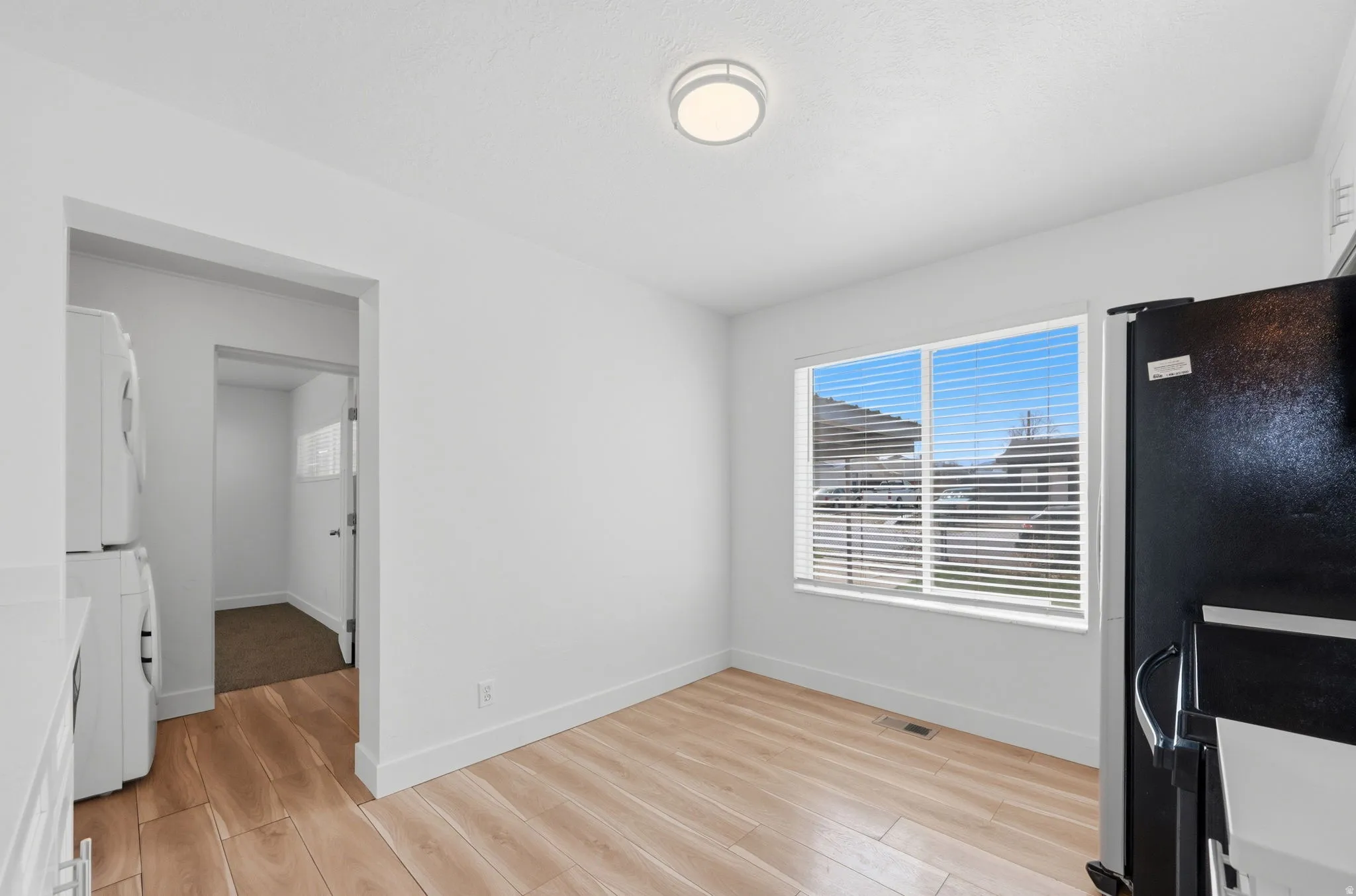 Unfurnished dining area with light wood-type flooring and baseboards