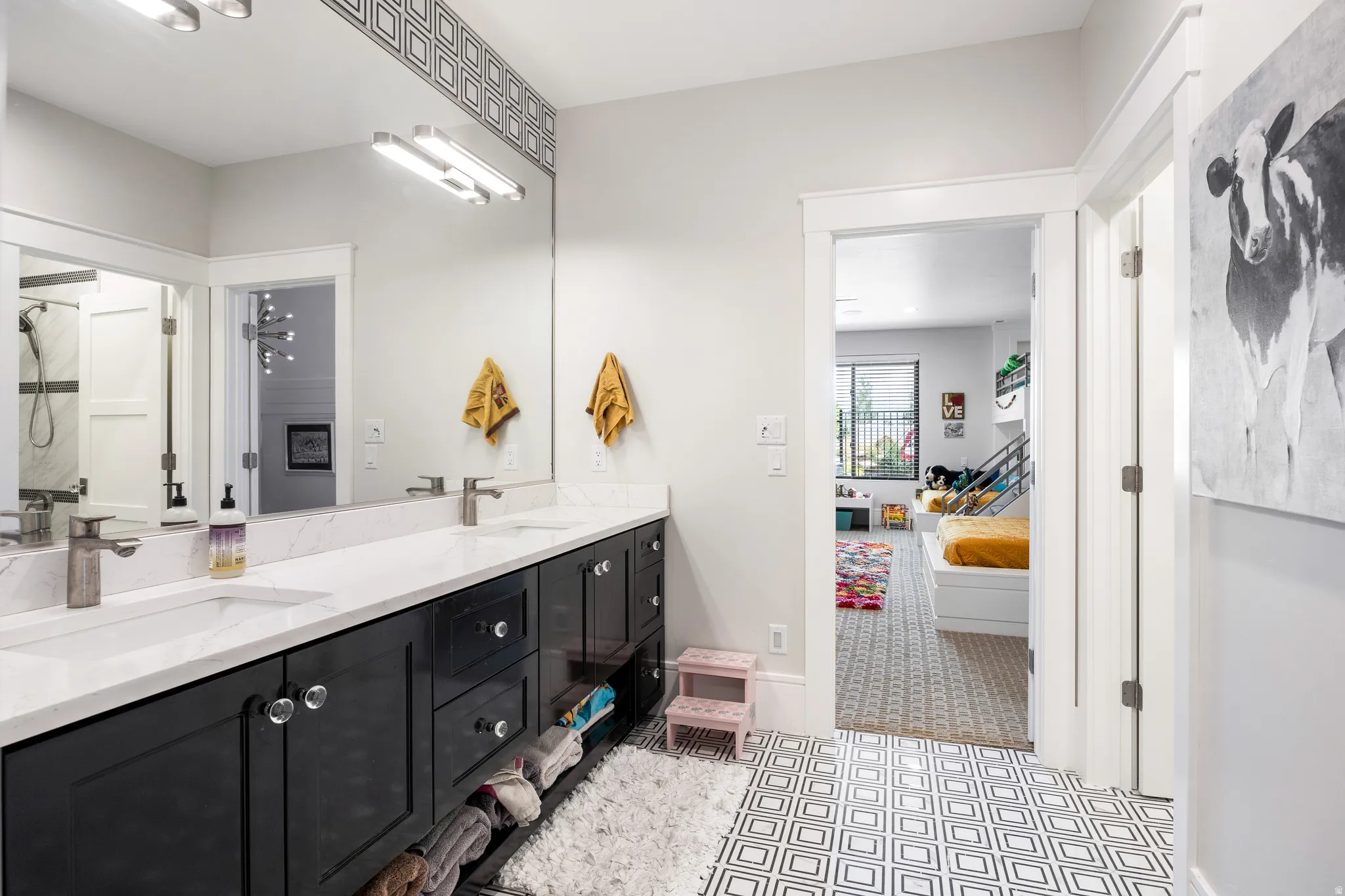 Ensuite bathroom with double vanity, a shower, and light flooring