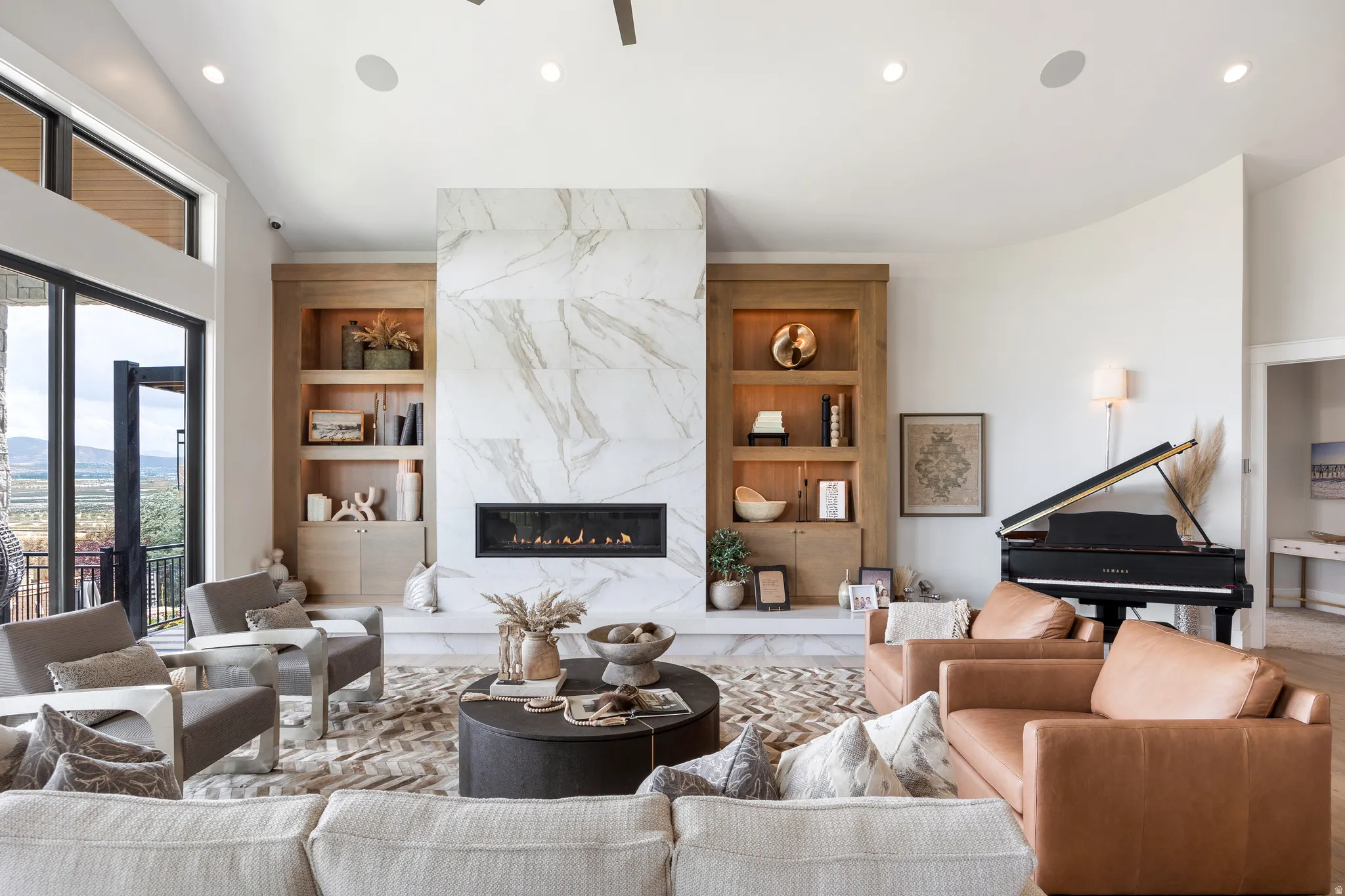 Living area featuring built in shelves, a premium fireplace, recessed lighting, and vaulted ceiling