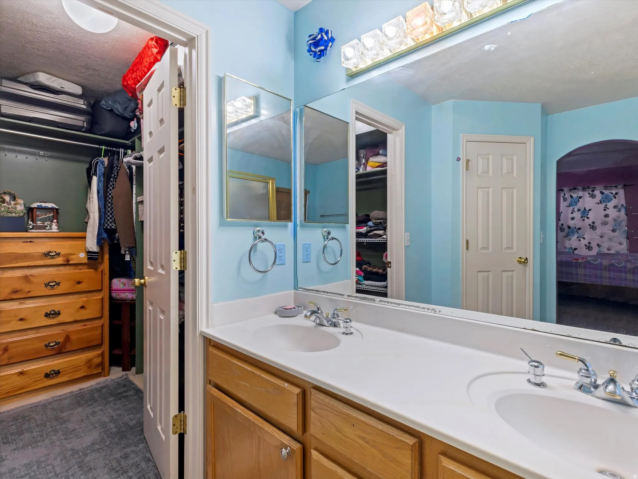 Ensuite bathroom featuring a walk in closet and double vanity
