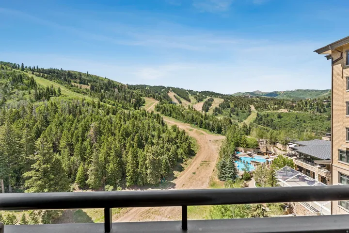 Expansive mountain landscape featuring dense evergreen forests and visible ski slopes