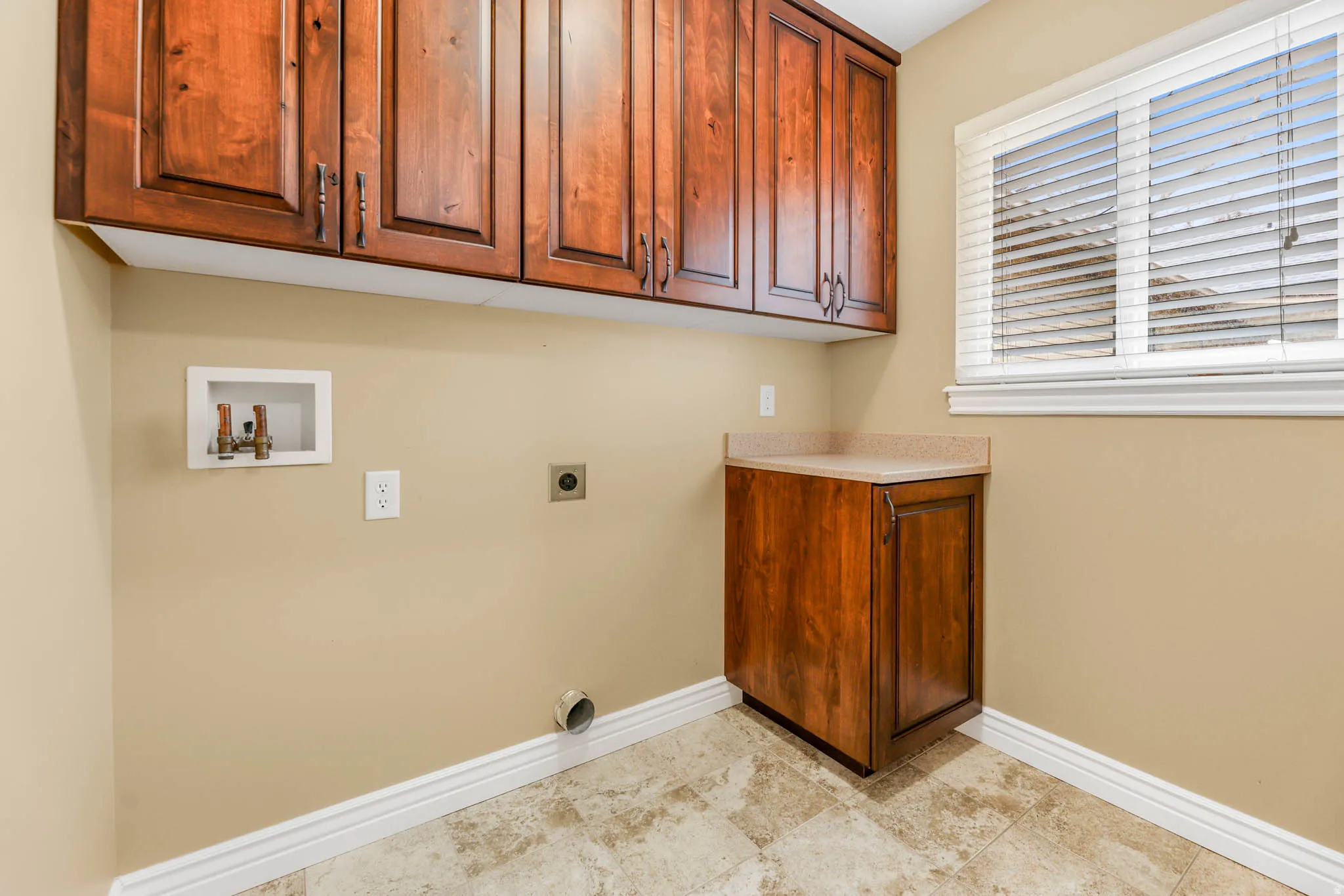 Laundry room with cabinet space, hookup for an electric dryer, and washer hookup