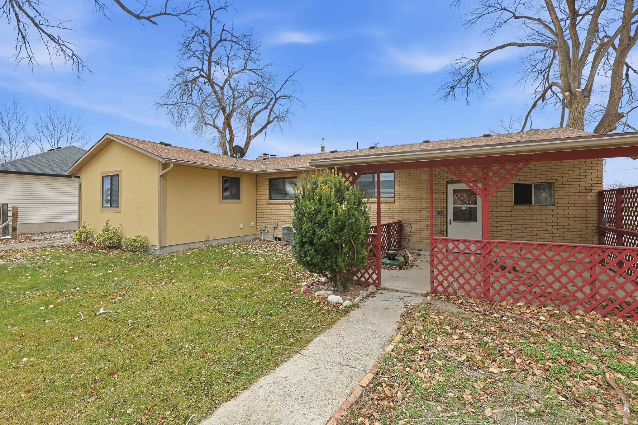 Back of property featuring a yard, stucco siding, and brick siding