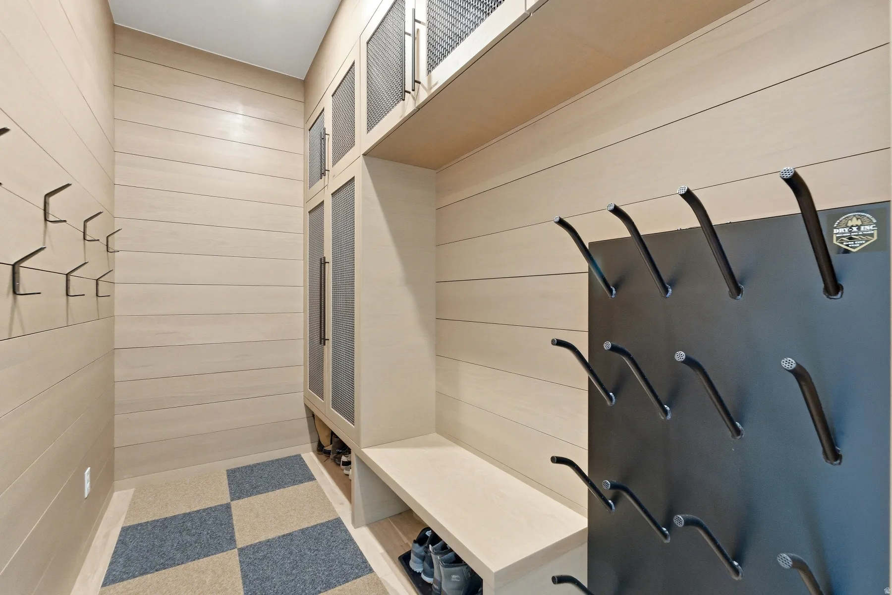 Mudroom featuring tile patterned floors and wood walls
