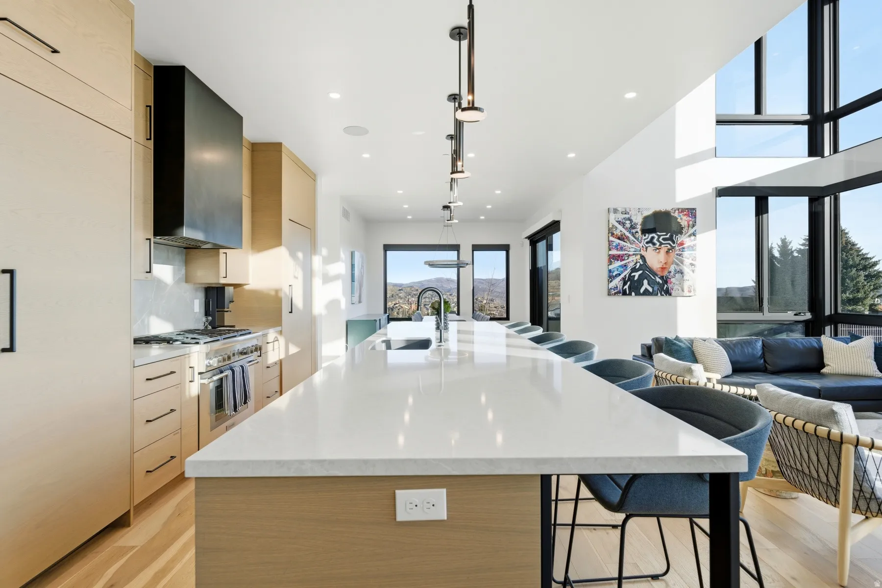 Kitchen featuring modern cabinets, light brown cabinetry, a kitchen bar, a spacious island, and recessed lighting