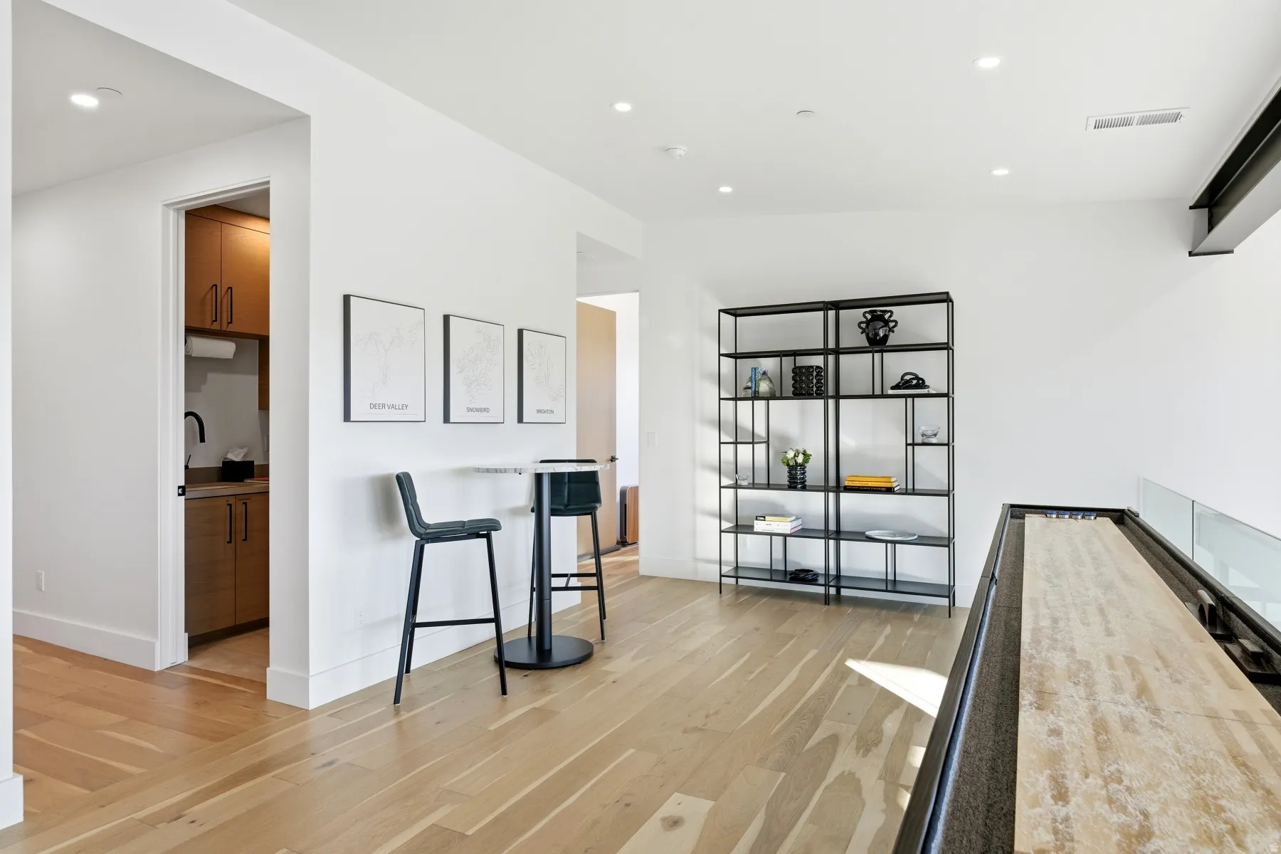 Living area with light wood-style flooring and recessed lighting