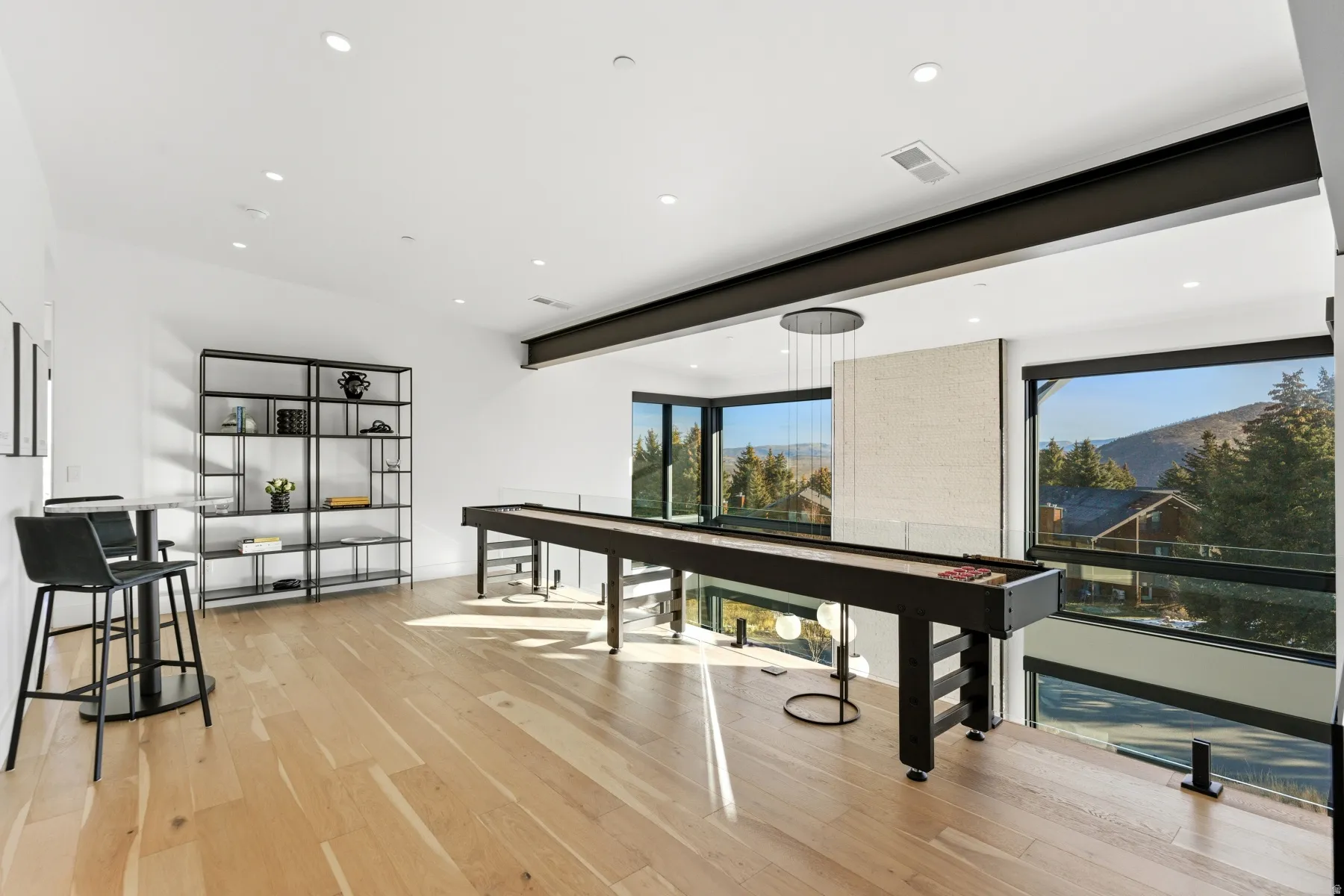 Recreation room featuring light wood finished floors, recessed lighting, and beamed ceiling