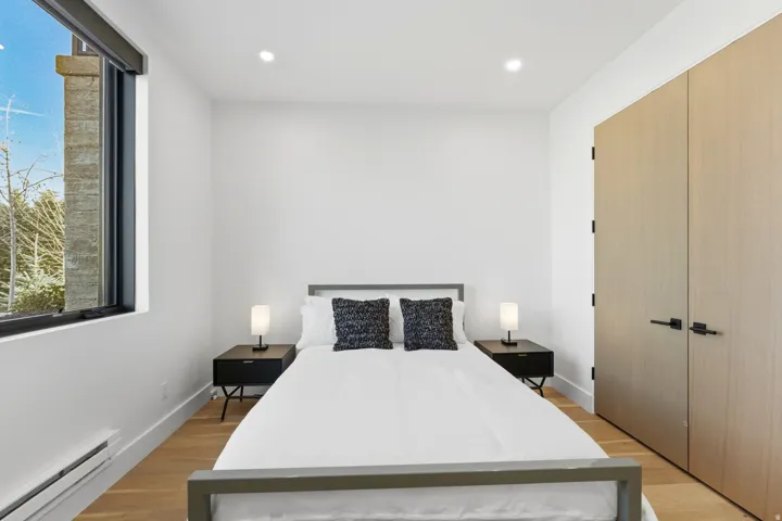 Bedroom with a baseboard radiator, a closet, light wood-style floors, and recessed lighting