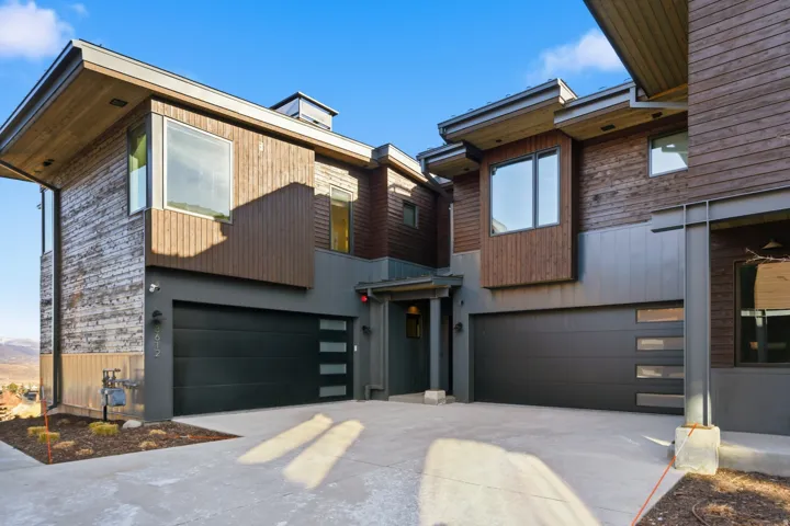 Contemporary house featuring concrete driveway and an attached garage