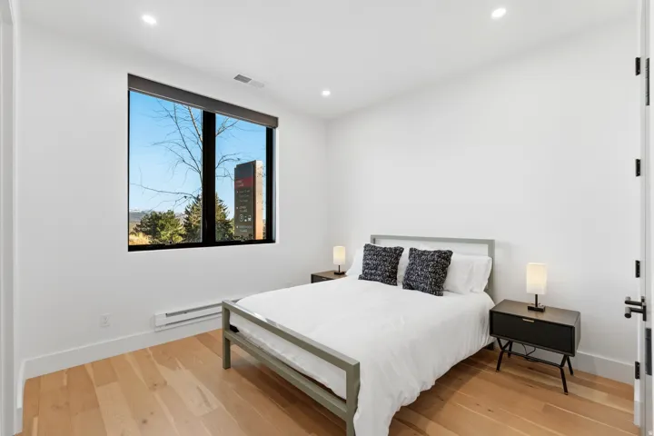Bedroom featuring light wood-style floors, a baseboard heating unit, and recessed lighting