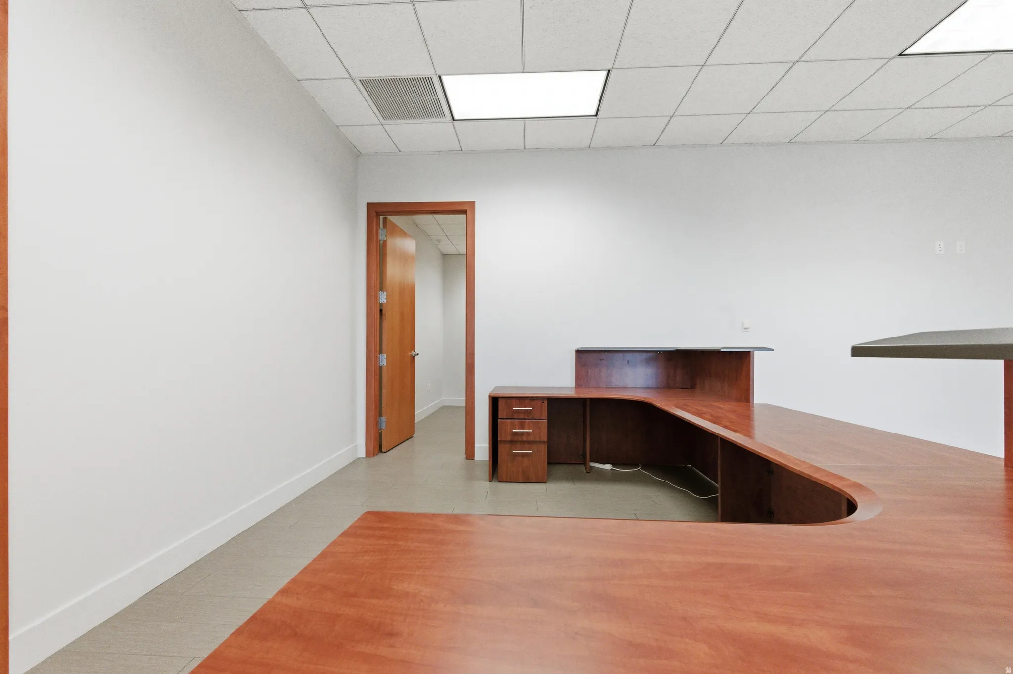 Unfurnished office featuring a drop ceiling
