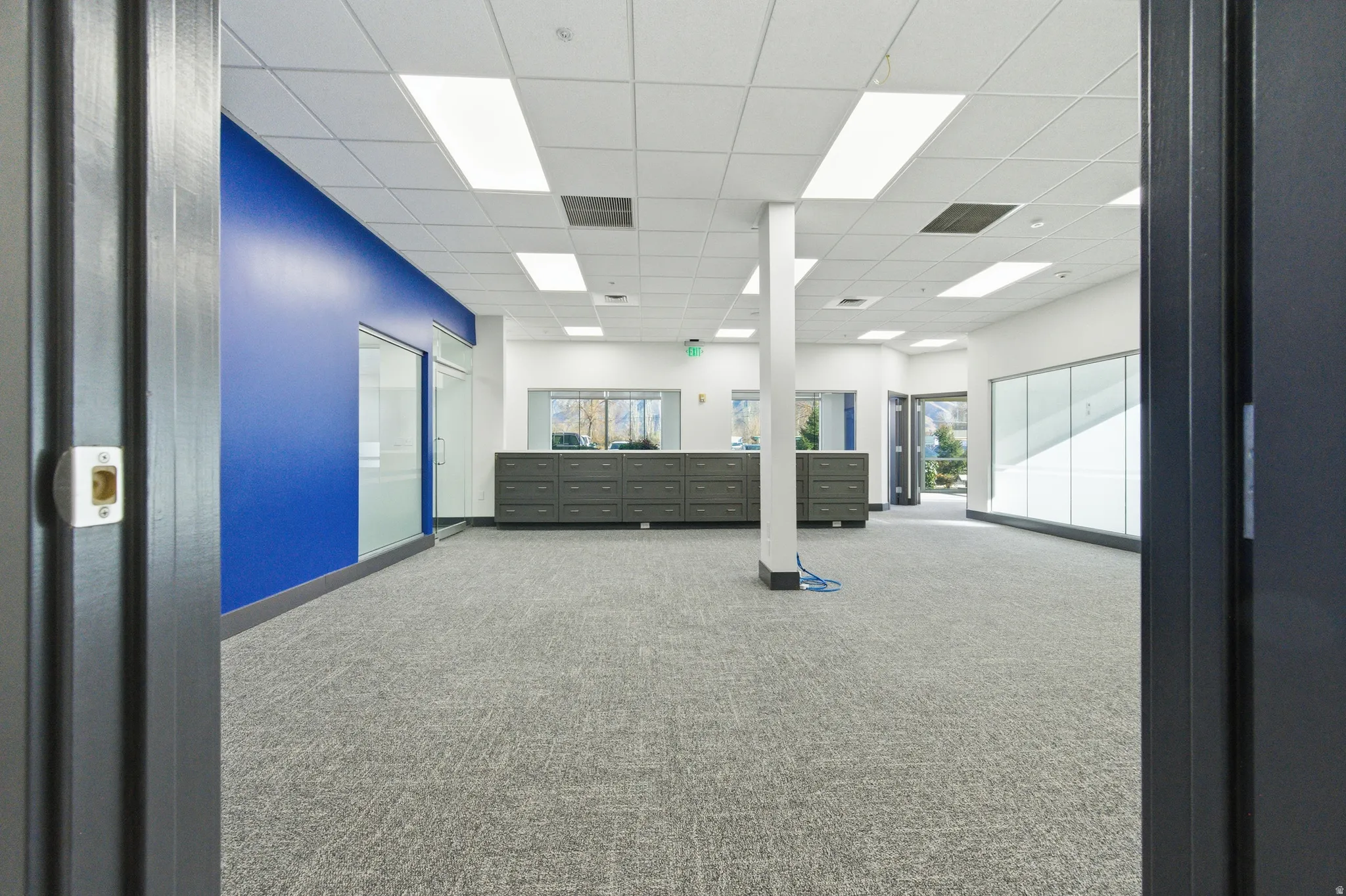 Carpeted spare room with a paneled ceiling and baseboards