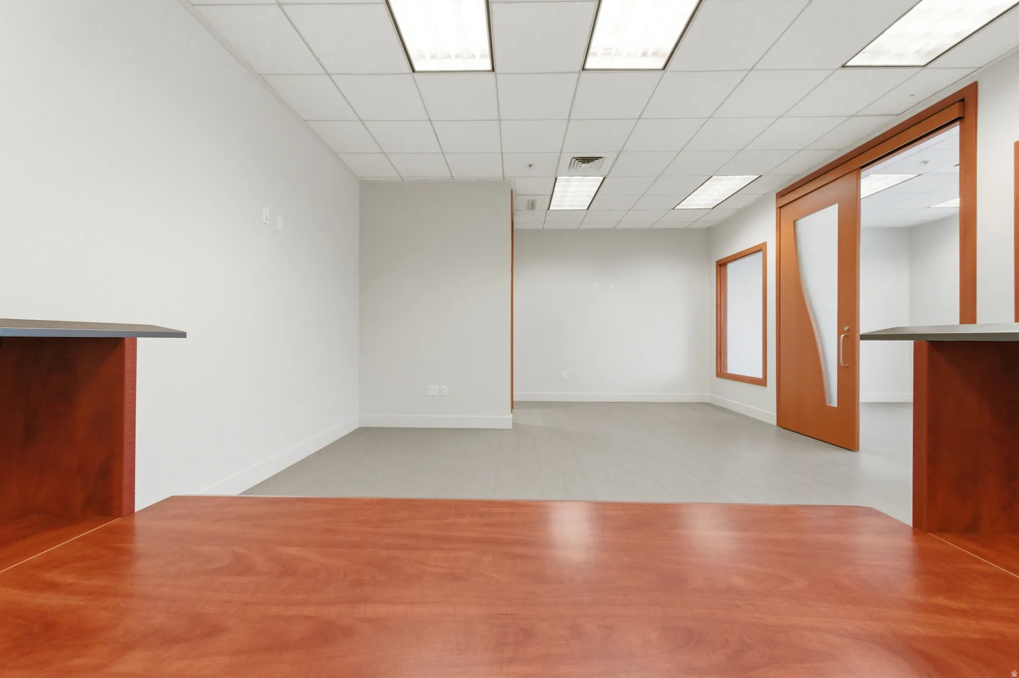 Unfurnished room featuring a drop ceiling and a dry bar