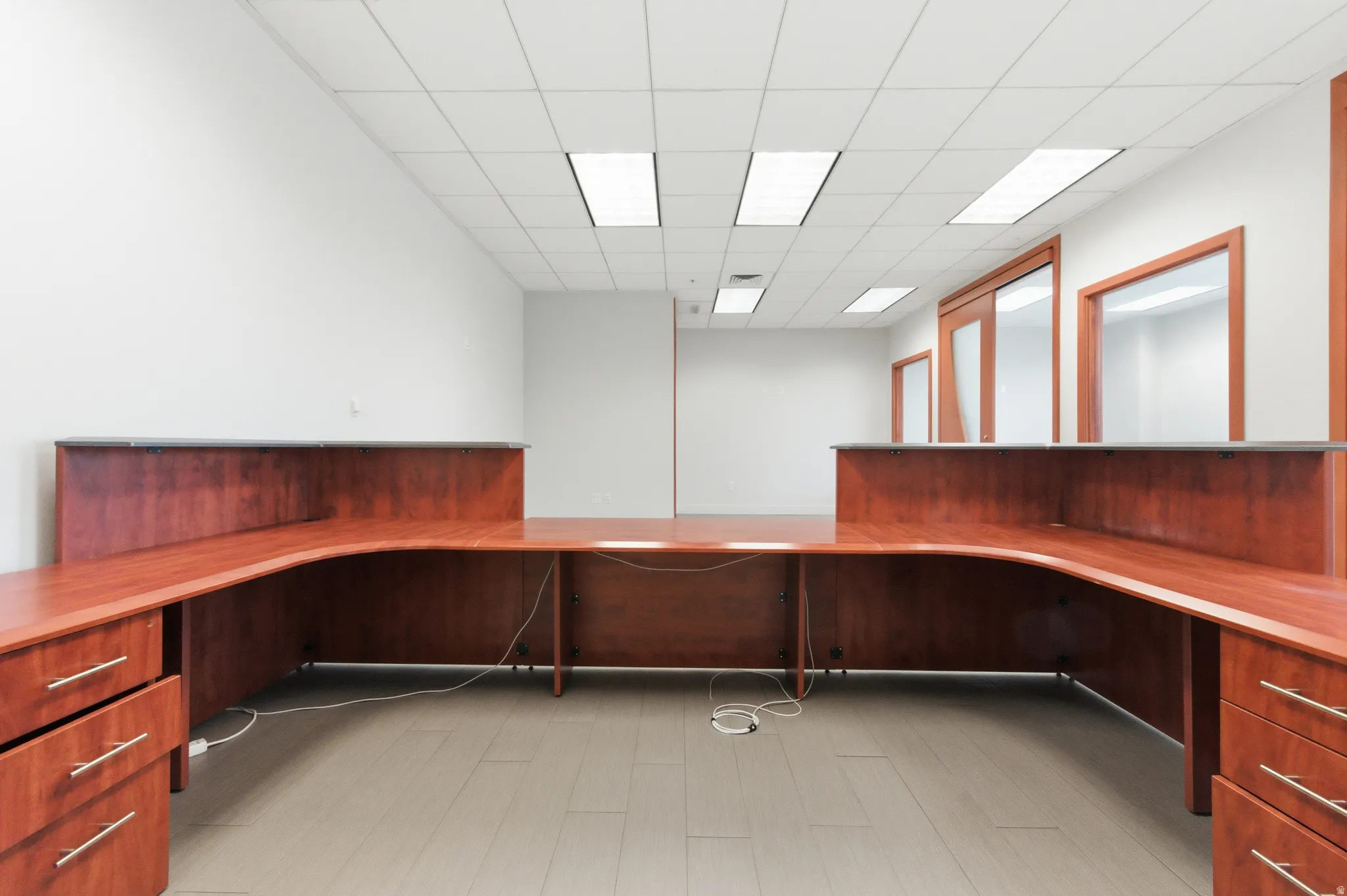 Unfurnished office featuring built in desk and a paneled ceiling