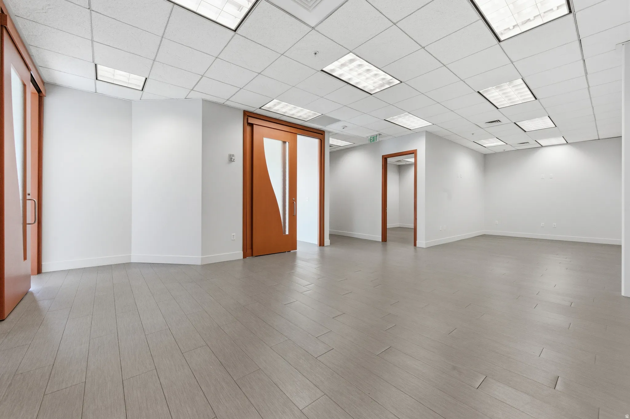 Empty room with light wood-style floors and a paneled ceiling