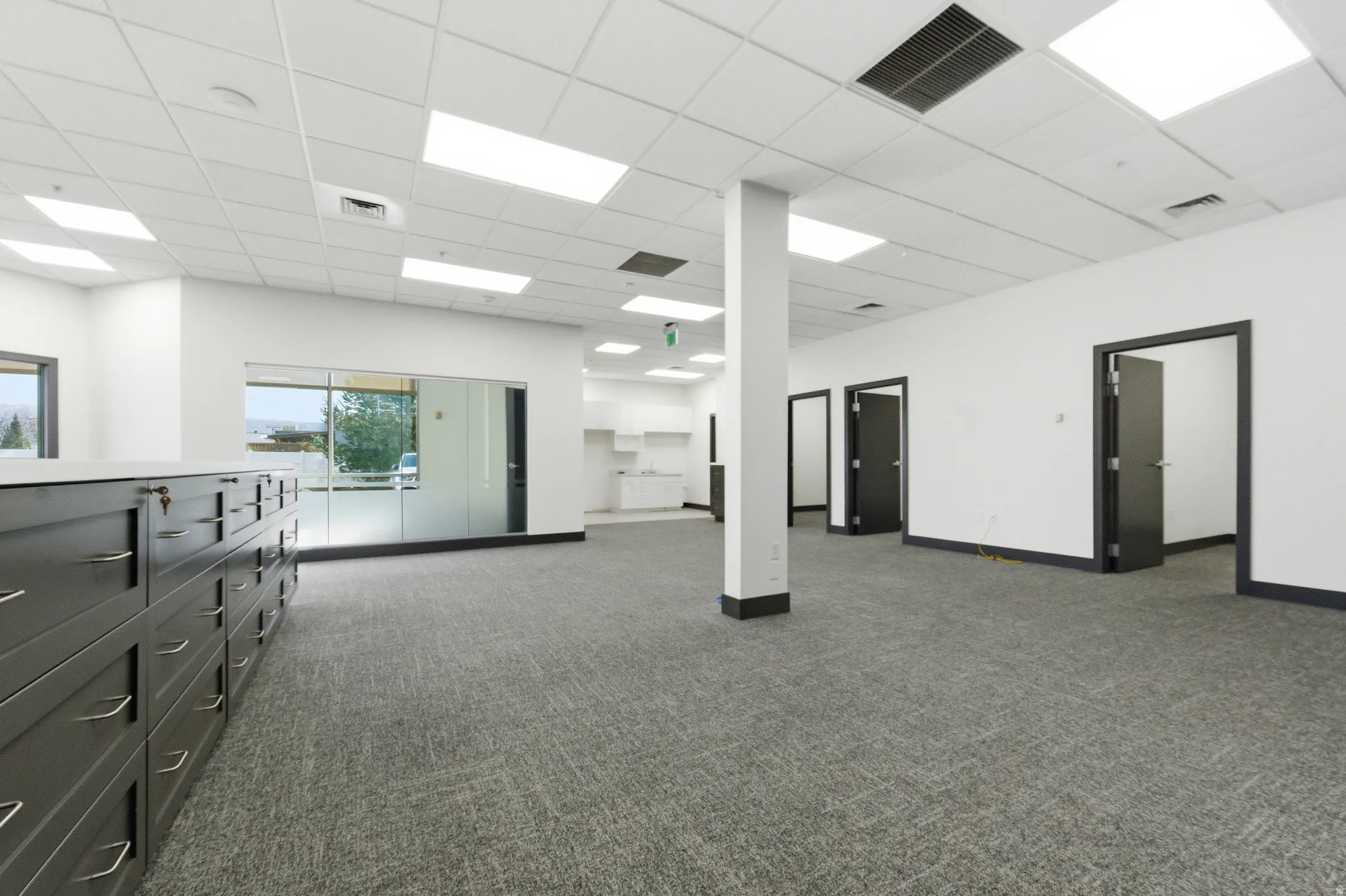 Spare room with a paneled ceiling and dark colored carpet
