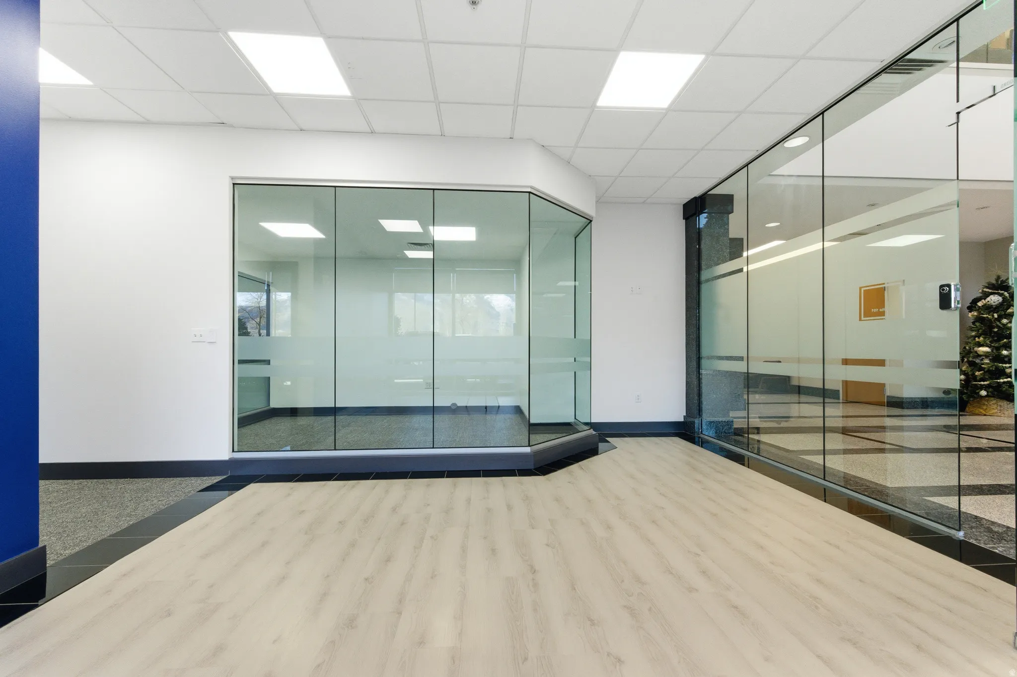 Unfurnished room with a drop ceiling and inlaid floor details