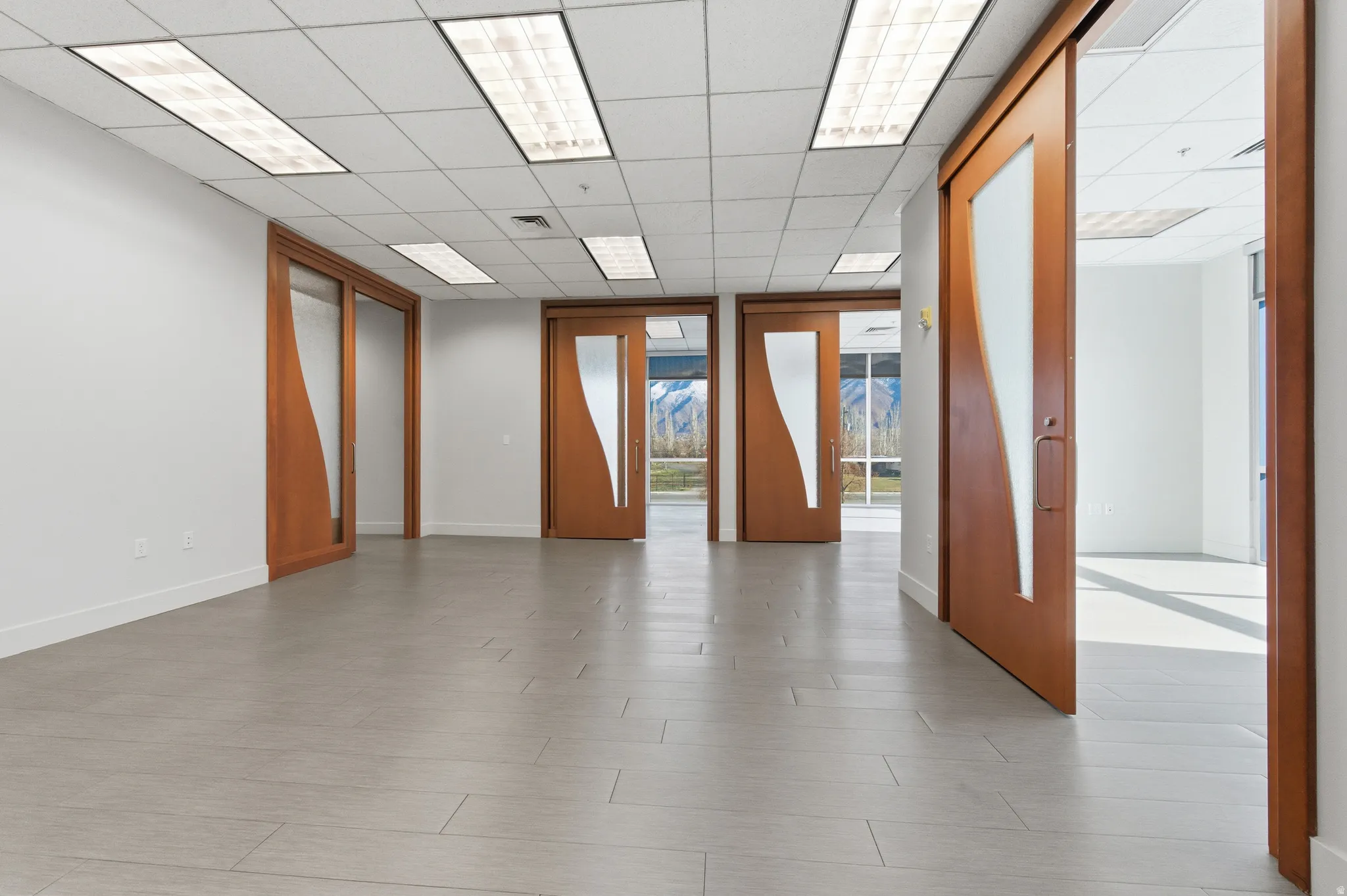 Unfurnished room featuring a paneled ceiling and baseboards