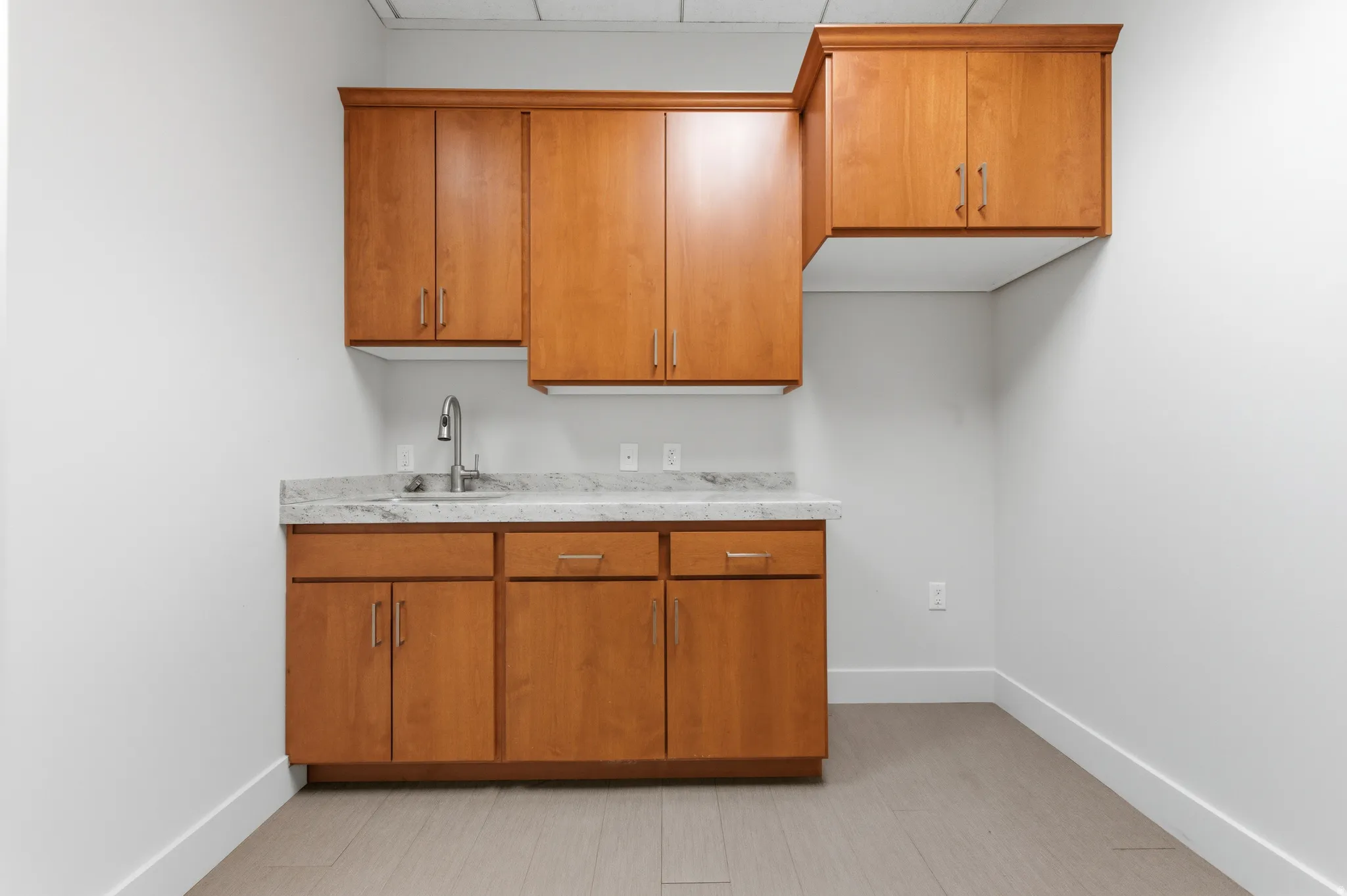 Kitchen featuring brown cabinetry and light countertops