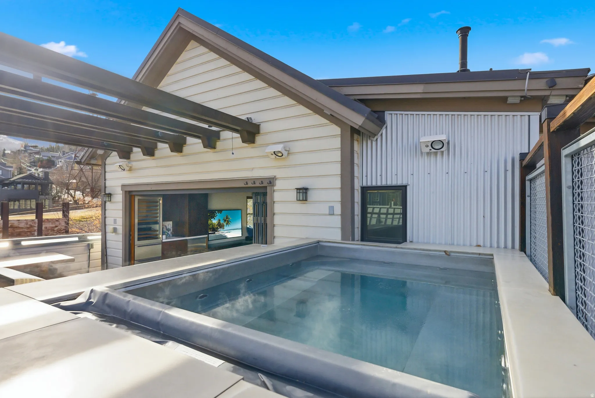 View of swimming pool with patio surround and a pergola