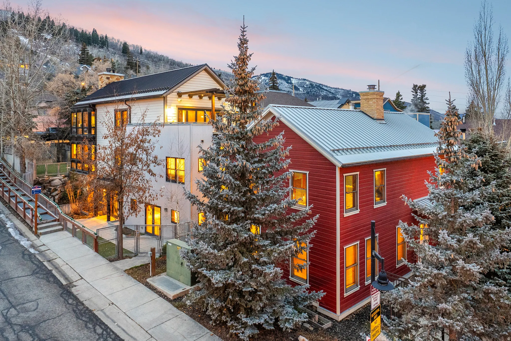 Property exterior at dusk with a chimney, a metal roof, a mountain view, and a gate