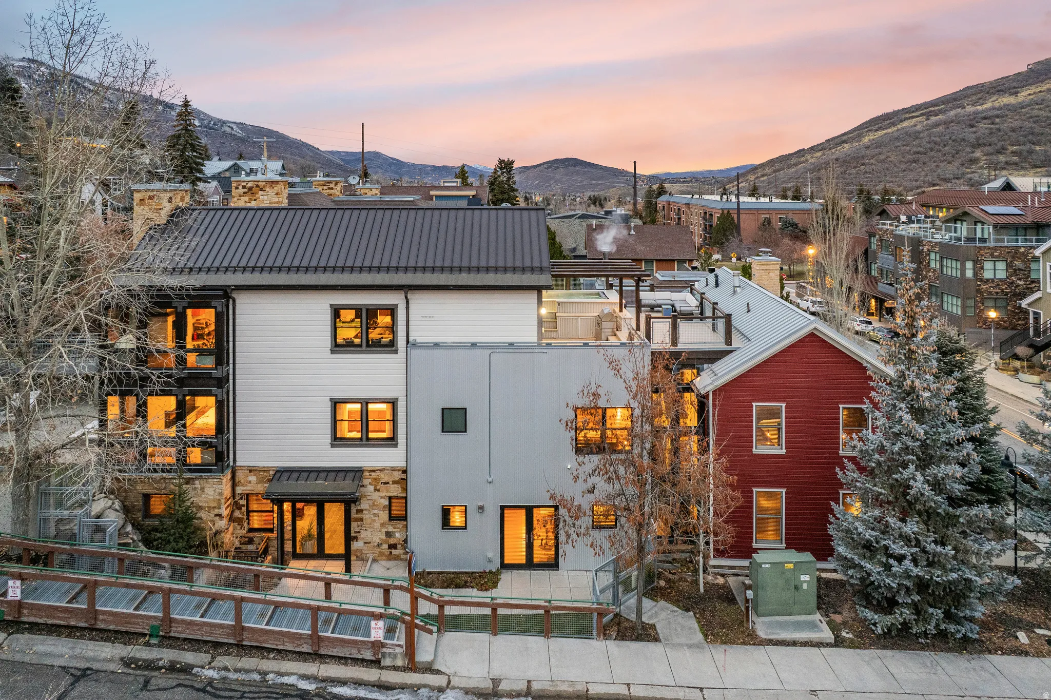 Back of house at dusk featuring a metal roof, a mountain view, and stone siding