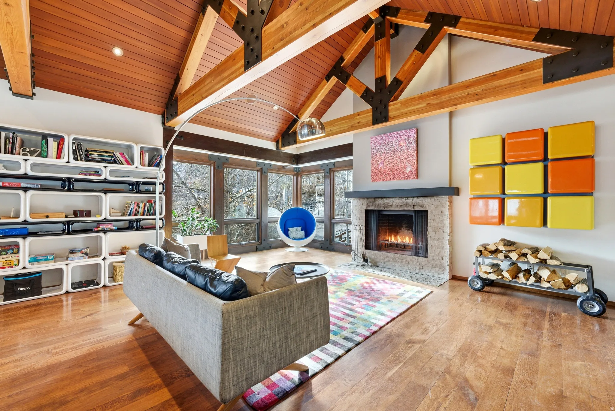 Living room with a high wood beamed ceiling, hardwood / wood-style flooring, and a fireplace