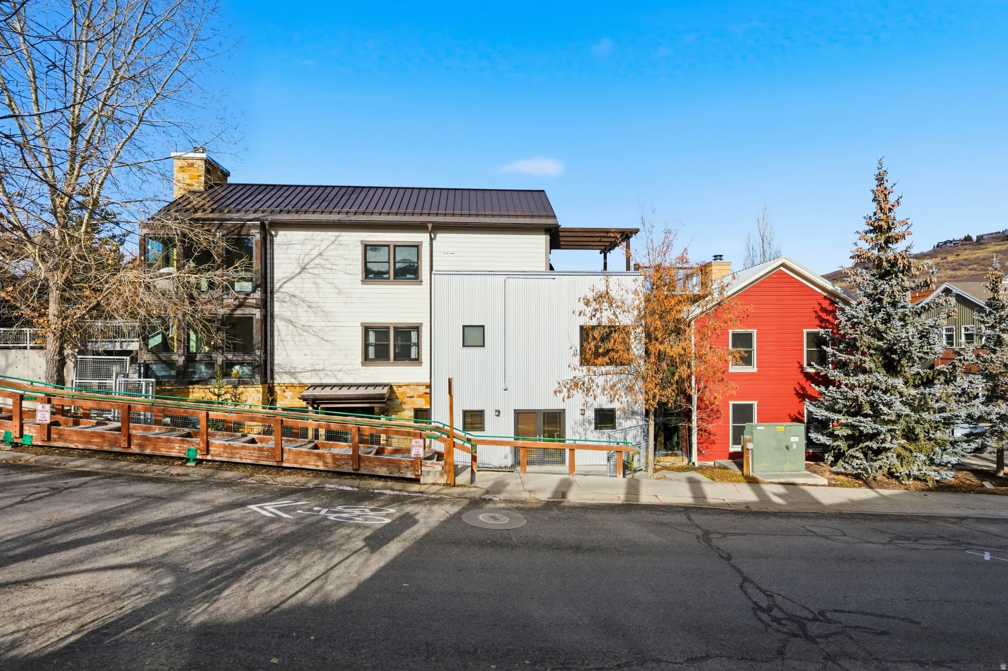 View of front of house featuring a fenced front yard, a chimney, and a metal roof