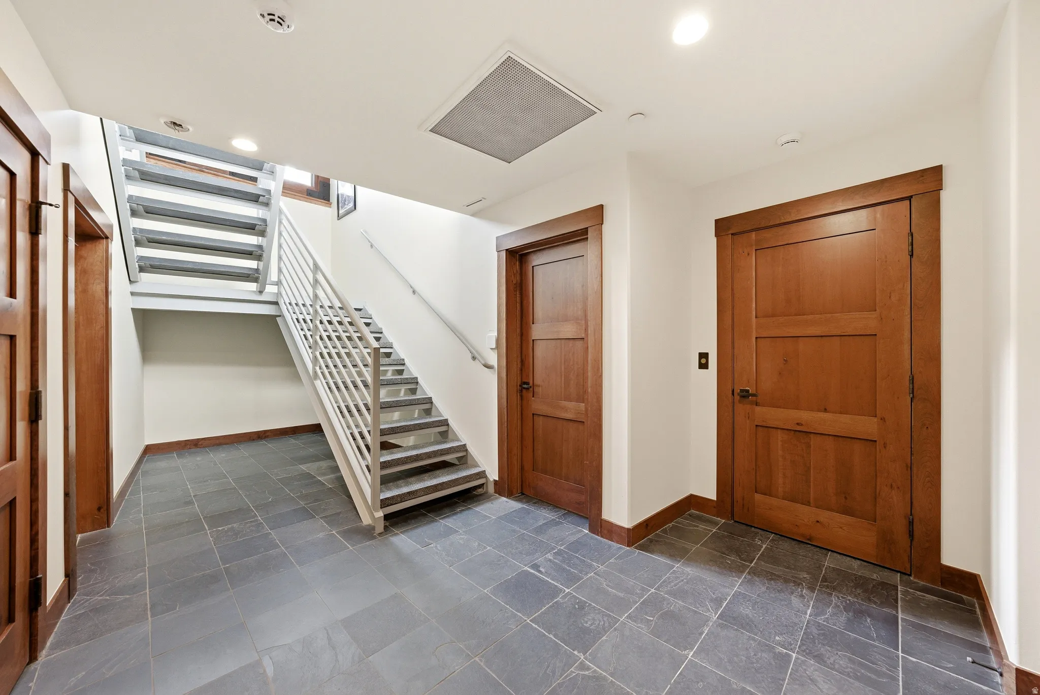 Foyer featuring dark stone finish floors and recessed lighting