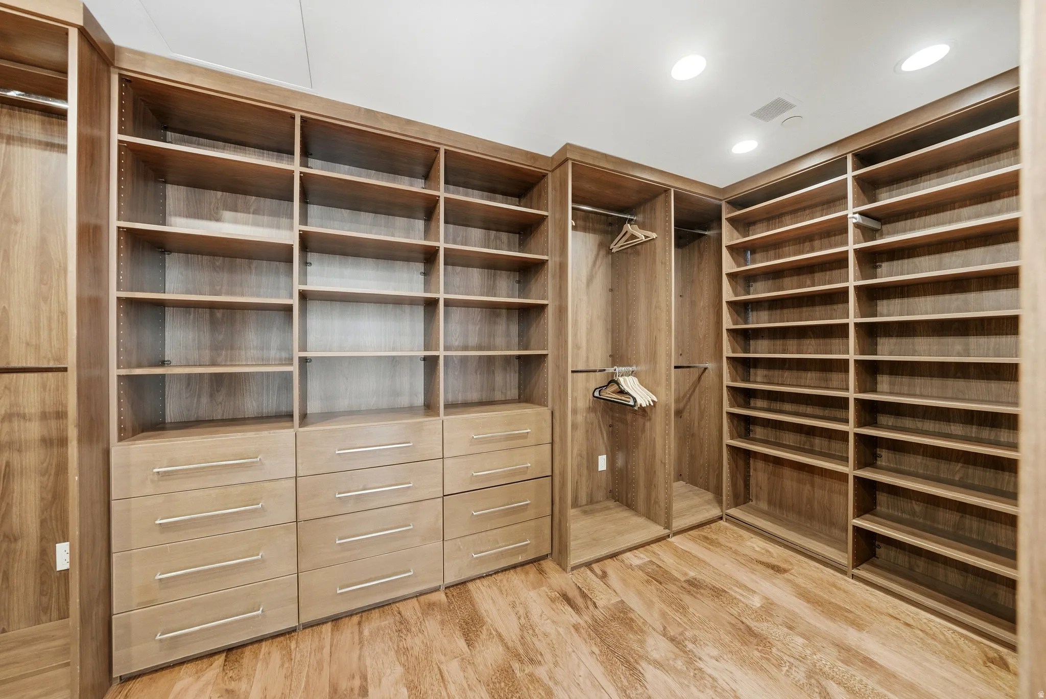 Walk in closet with light wood-style floors