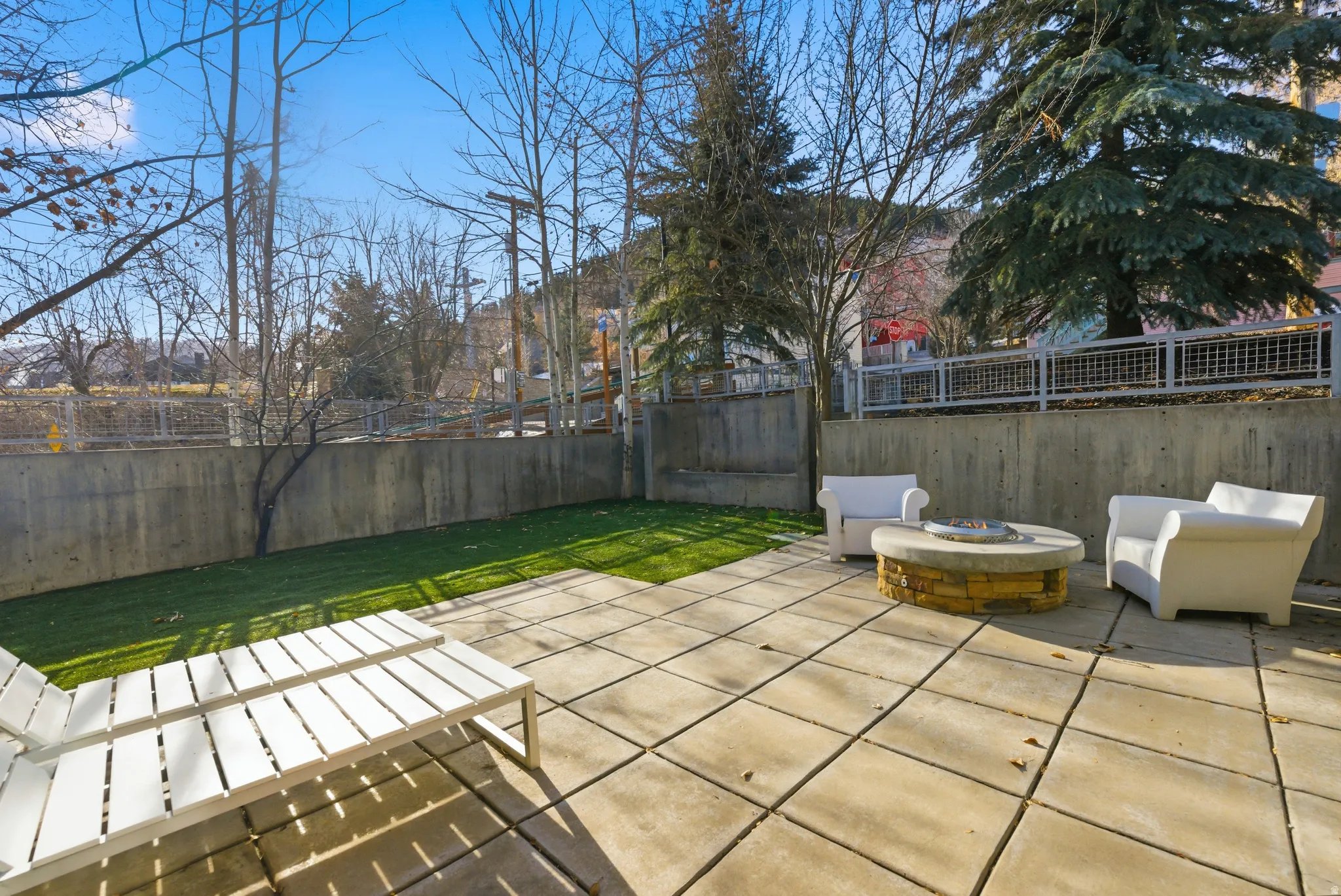 Fenced backyard with an outdoor fire pit and a patio