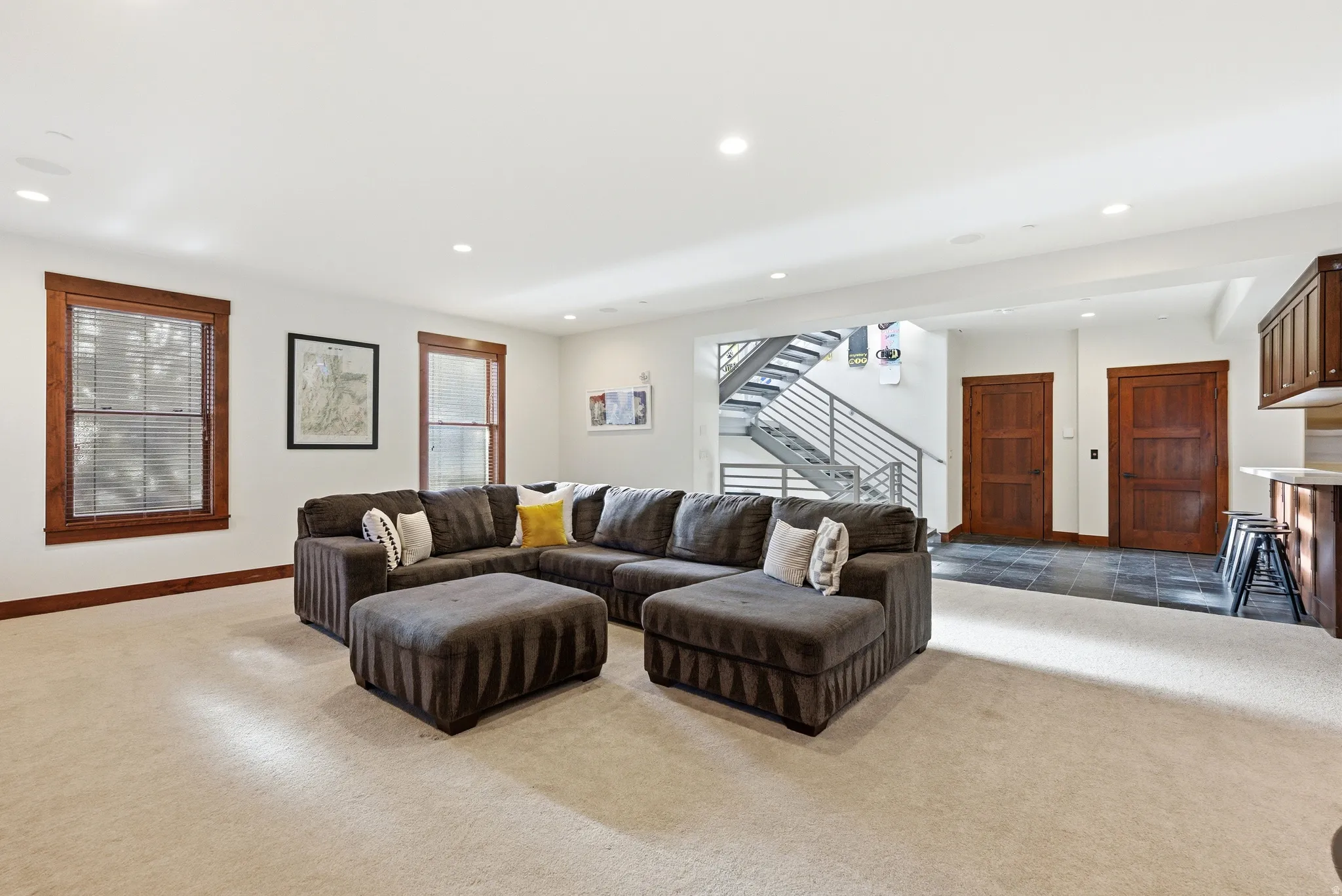 Living area with recessed lighting and dark colored carpet