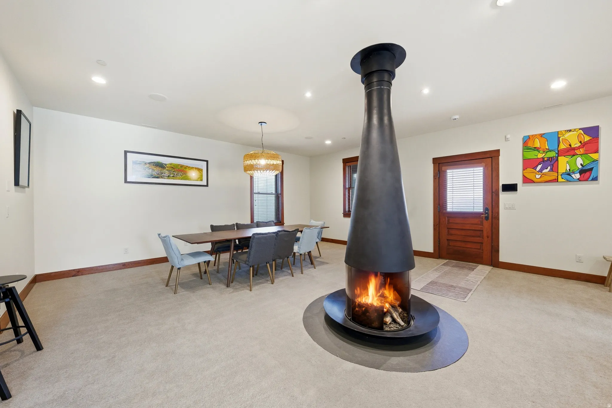Dining space with light colored carpet, recessed lighting, healthy amount of natural light, and a wood stove