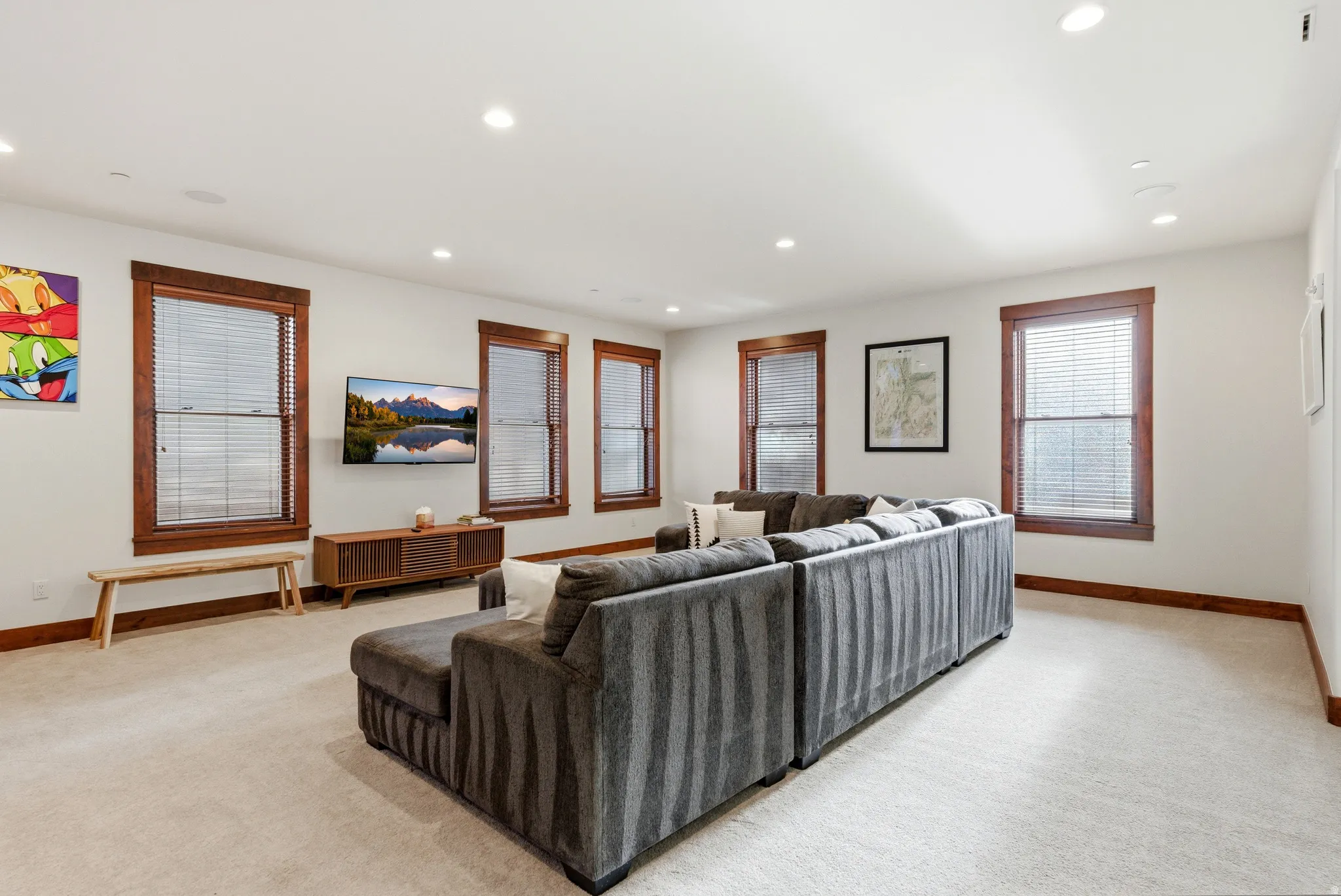 Living area with light carpet and recessed lighting