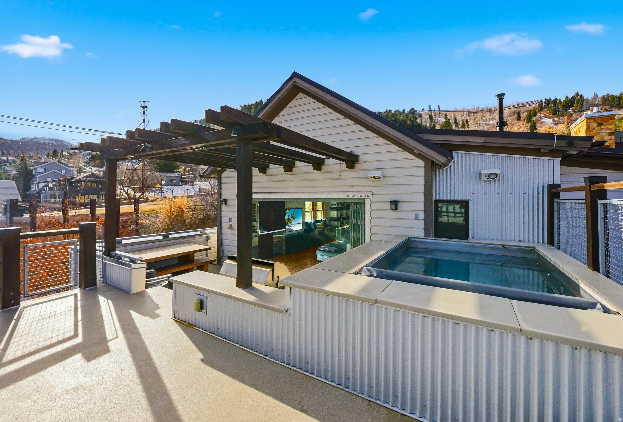 View of patio featuring a hot tub, a pergola, and a residential view