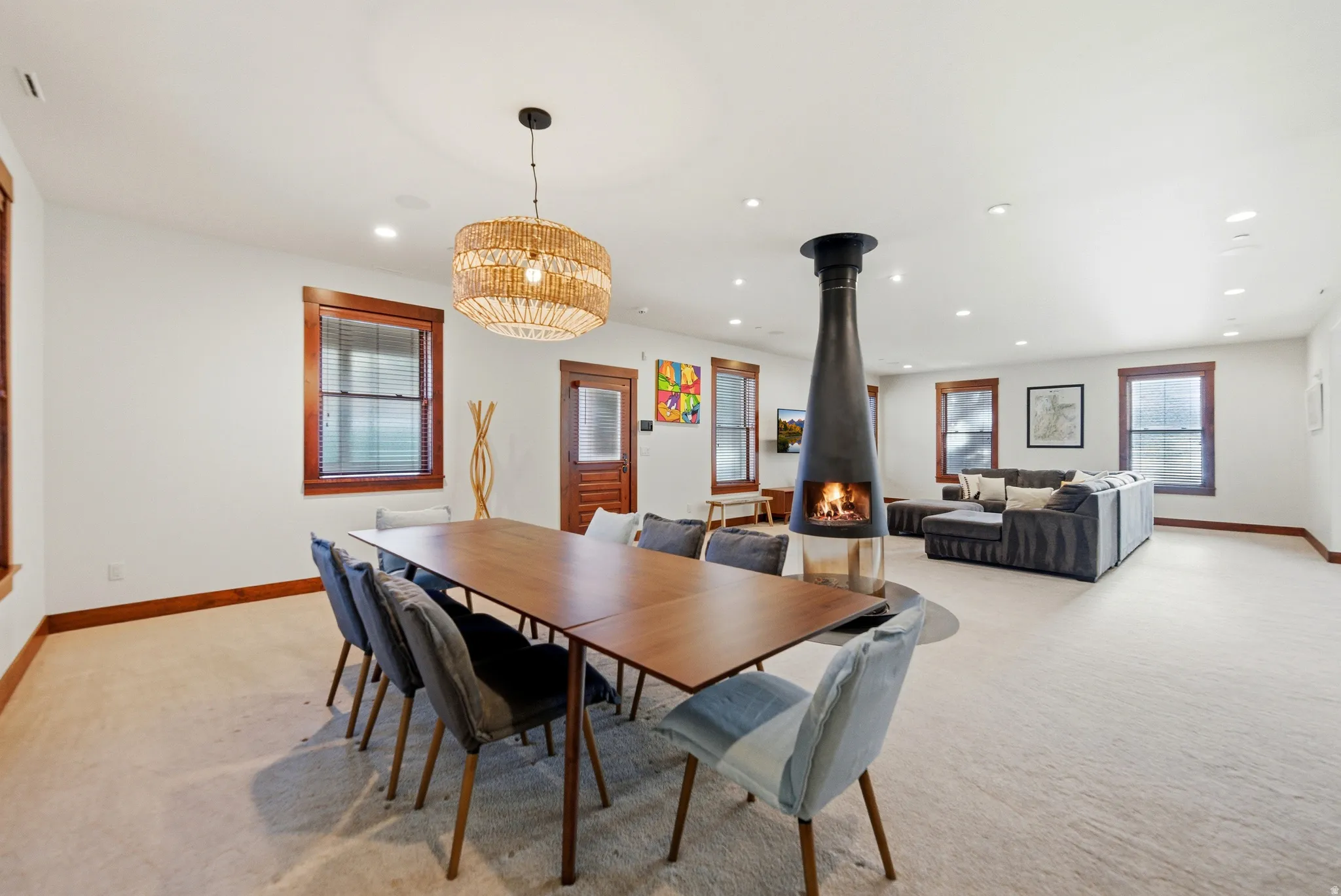 Dining space with light carpet, recessed lighting, and a wood stove
