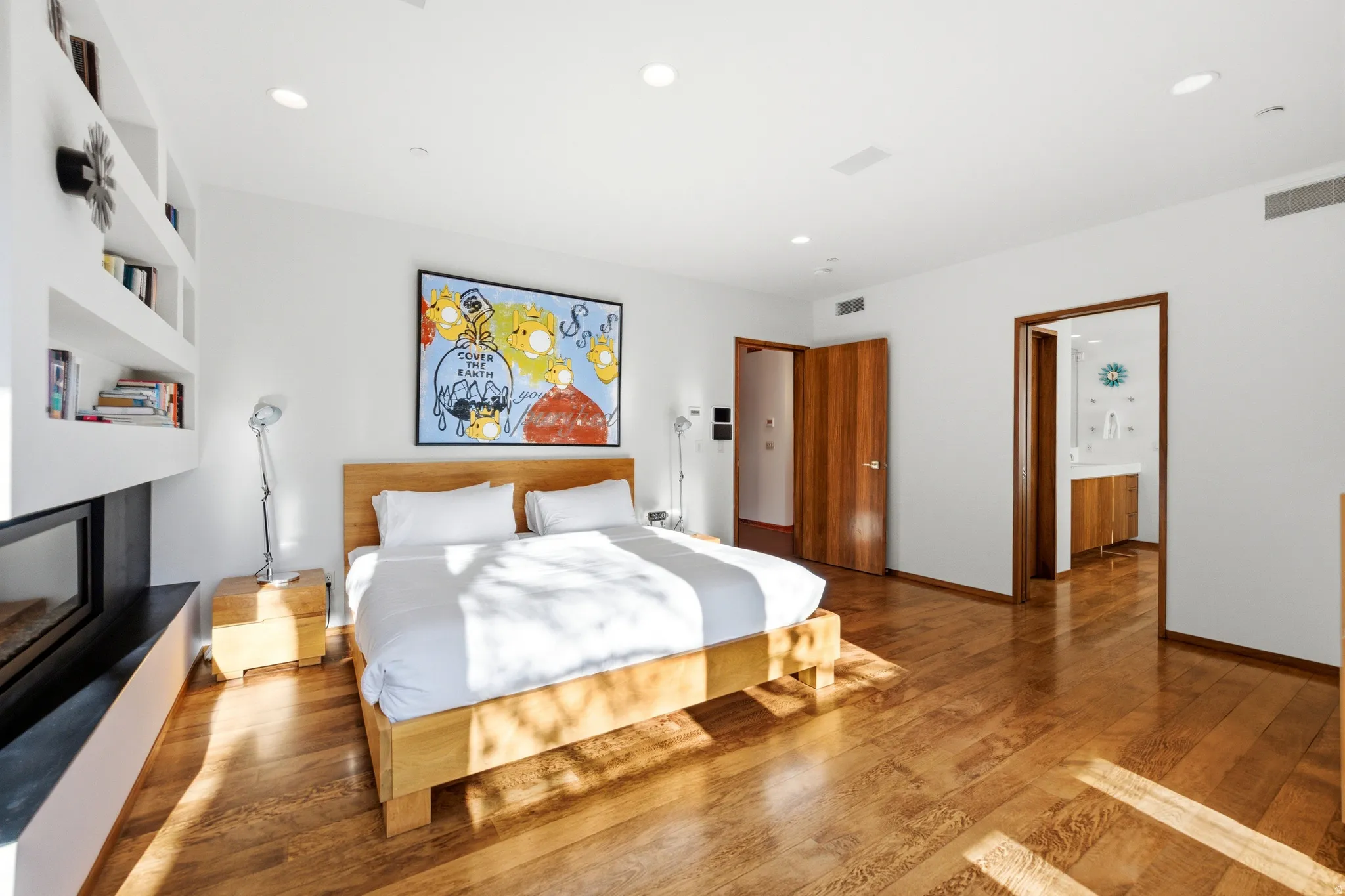 Bedroom featuring wood finished floors, recessed lighting, and a fireplace with raised hearth