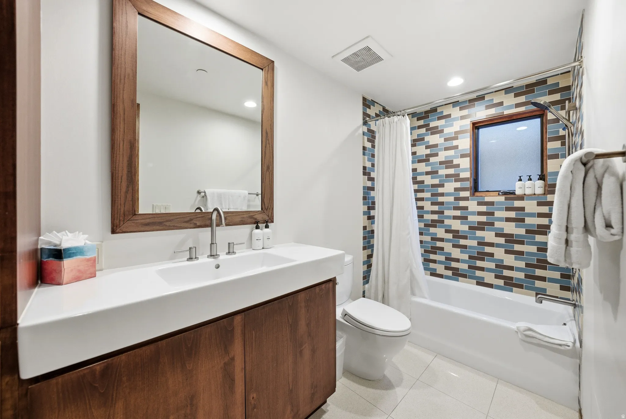 Bathroom with shower / bath combination with curtain, vanity, light tile patterned floors, and recessed lighting